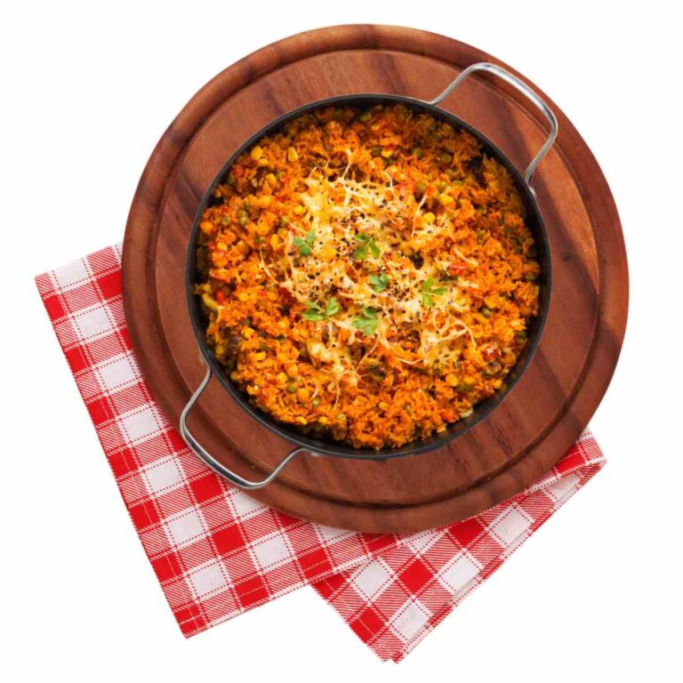 Spicy Mexican arice in a pot on a round wooden cutting board with red checked cloth.