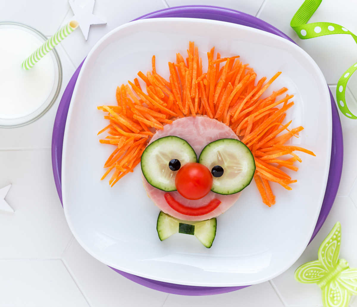 Clown made out of vegetables on a white plate.