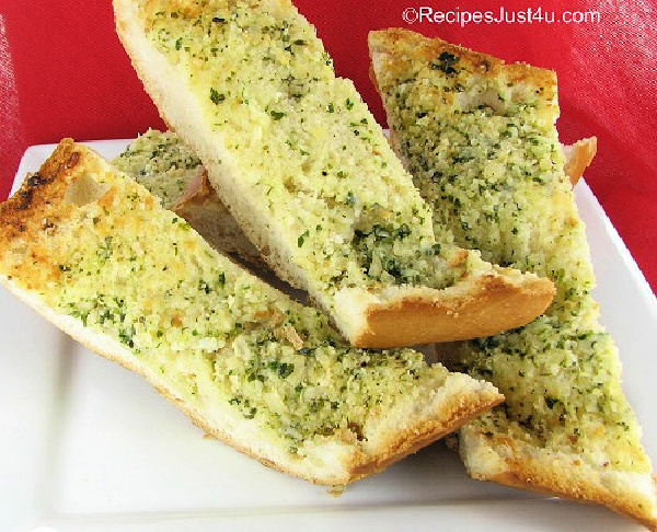 Slices of homemade Parmesan garlic bread on a white plate.