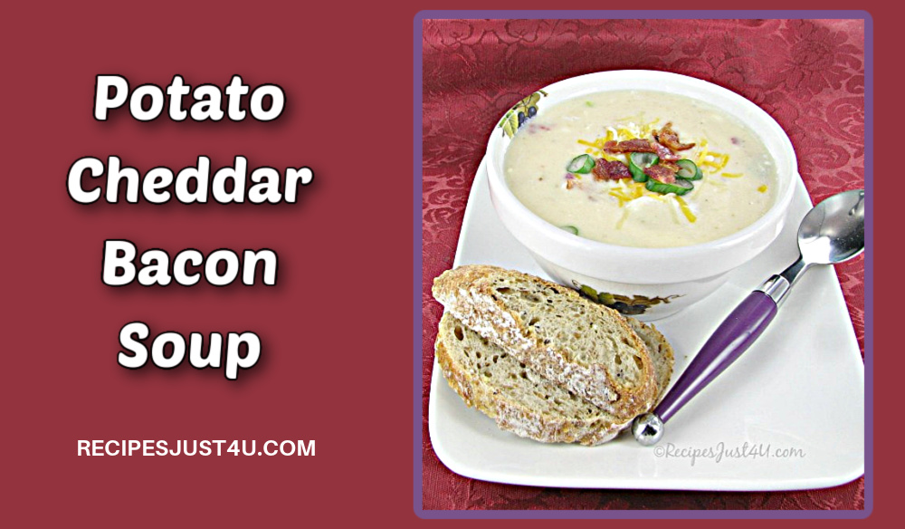 A bowl of potato cheddar bacon soup with crusty bread and a purple spoon.