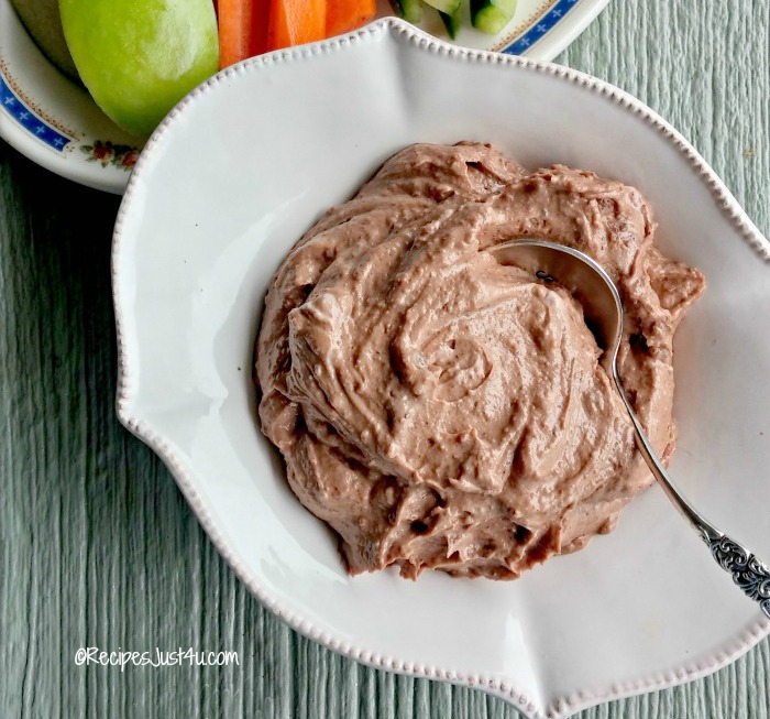 Healthy chocolate hazelnut fruit dip in a bowl with a spoon.
