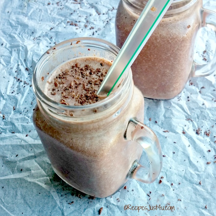 Smoothie in a mason jar with a straw and chocolate shavings.