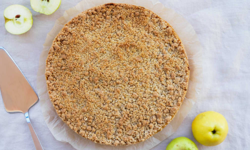 Crumble crust with pie server and apple halves.