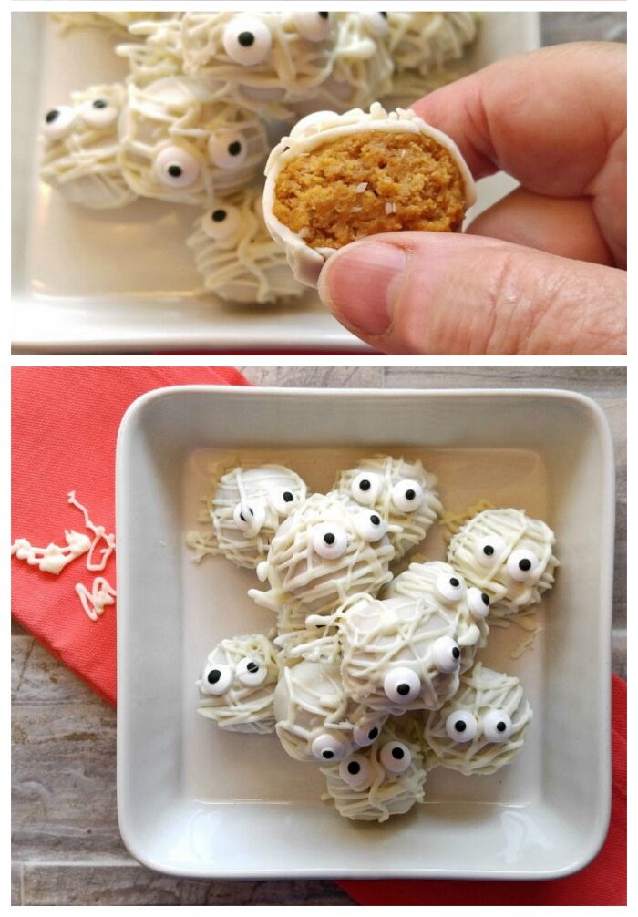 Mummy pumpkin balls A hand holding a pumpkin cheesecake truffle and a bowl of truffles decorated like mummies.