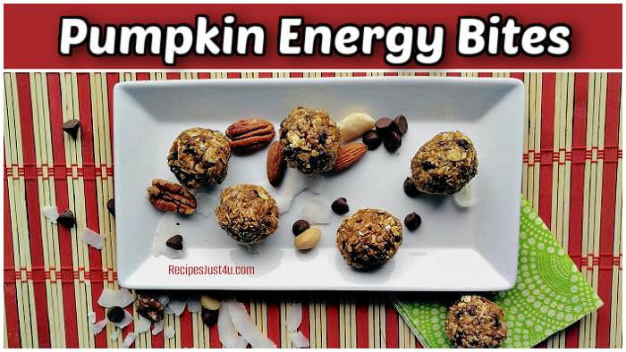Pumpkin energy bites on a white plate with nuts, coconut and chocolate chips.