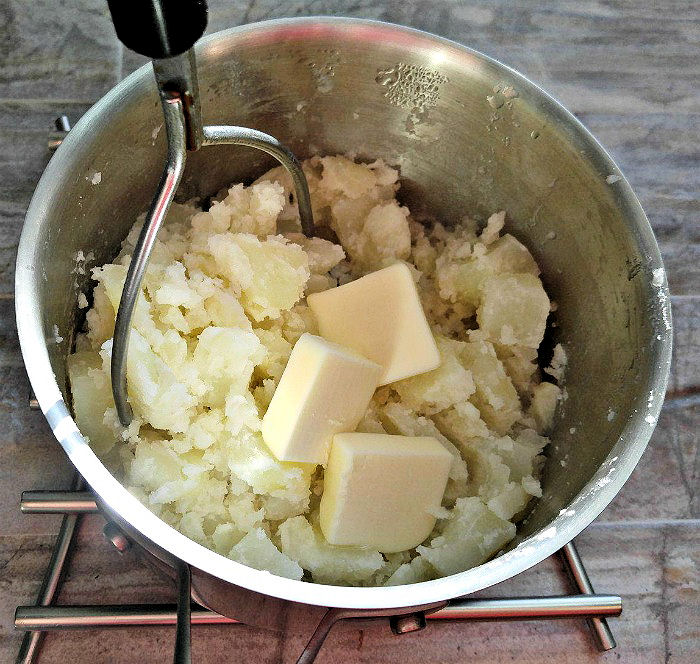 Adding butter to mashed potatoes