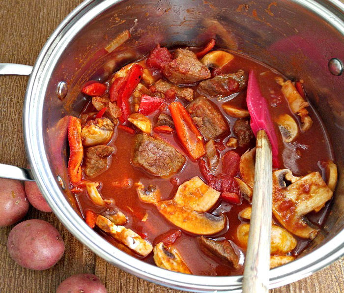 Tomato sauce and peppers to goulash pot