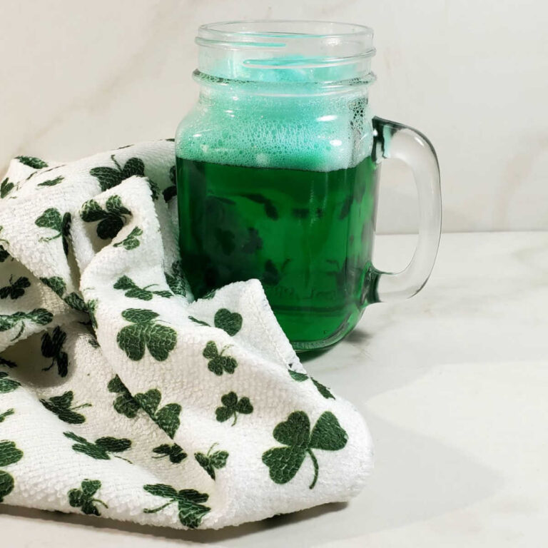 Green beer in a mug near a tea towel with shamrocks.