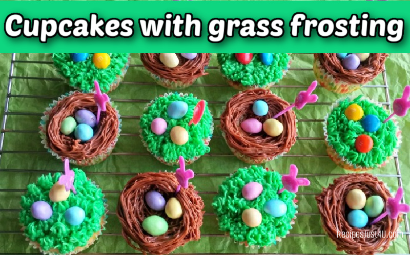Easter cupcakes with grass frosting and Easter egg decorations on a wire rack.