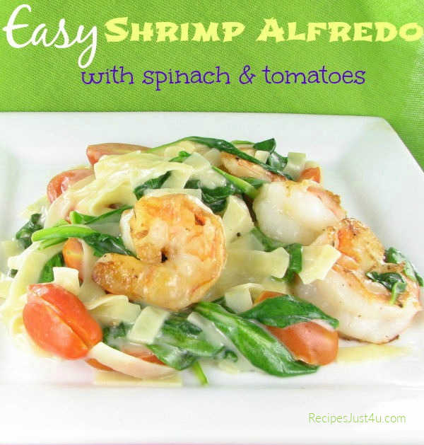 Shrimp Alfredo with spinach and tomatoes on a white plate. There's a green banner at the top reads Easy Shrimp Alfredo with spinach and tomatoes.