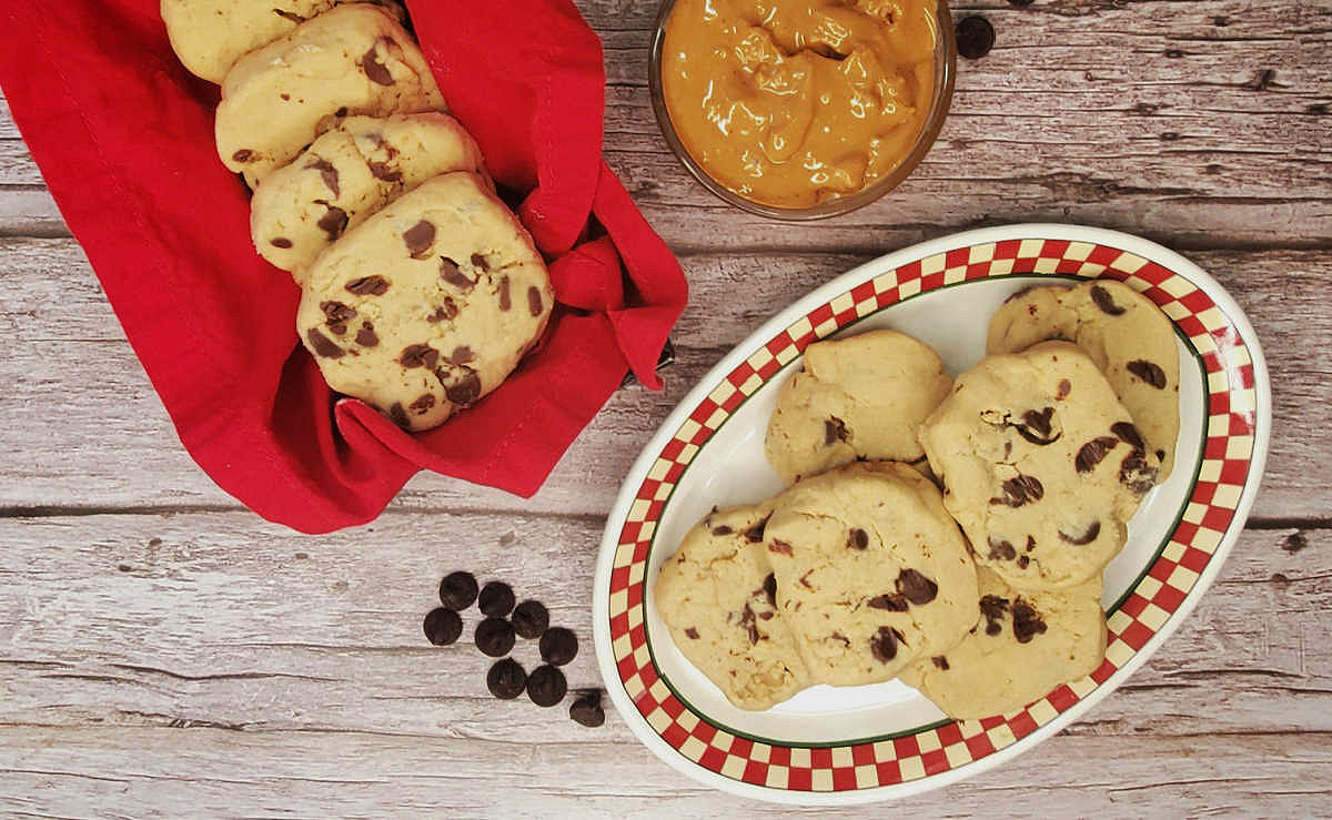 Peanut butter chocolate shortbread cookies Peanut butter chocolate shortbread cookies on a red plate next to a bowl of peanut butter and some chocolate chips.
