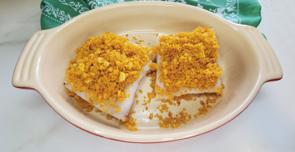 Two pieces of cod with a Ritz cracker topping in an ovenproof casserole dish.