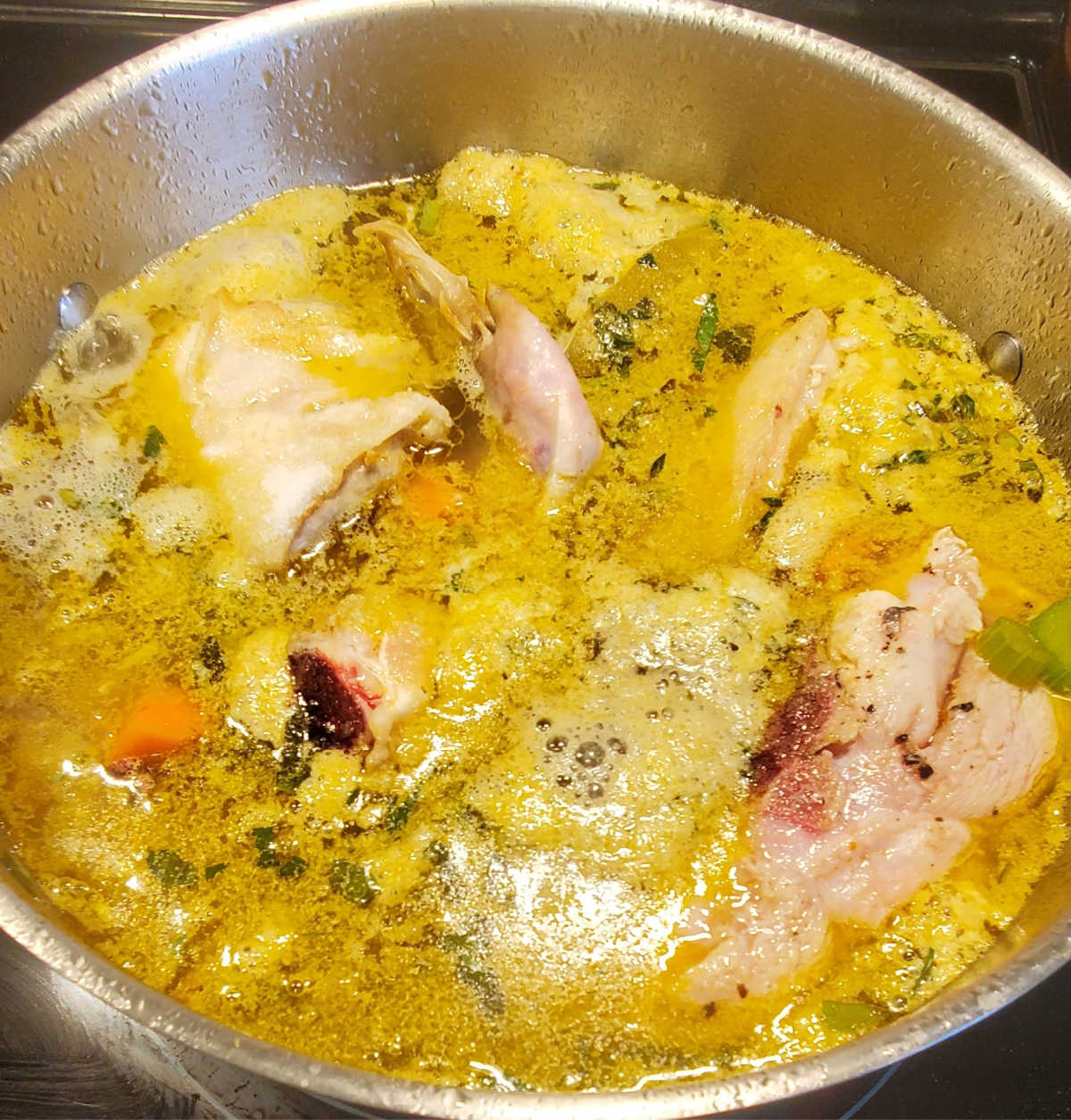 Cook the chicken and vegetables for 90 minutes. A large stockpot with chicken and vegetables cooking in it.