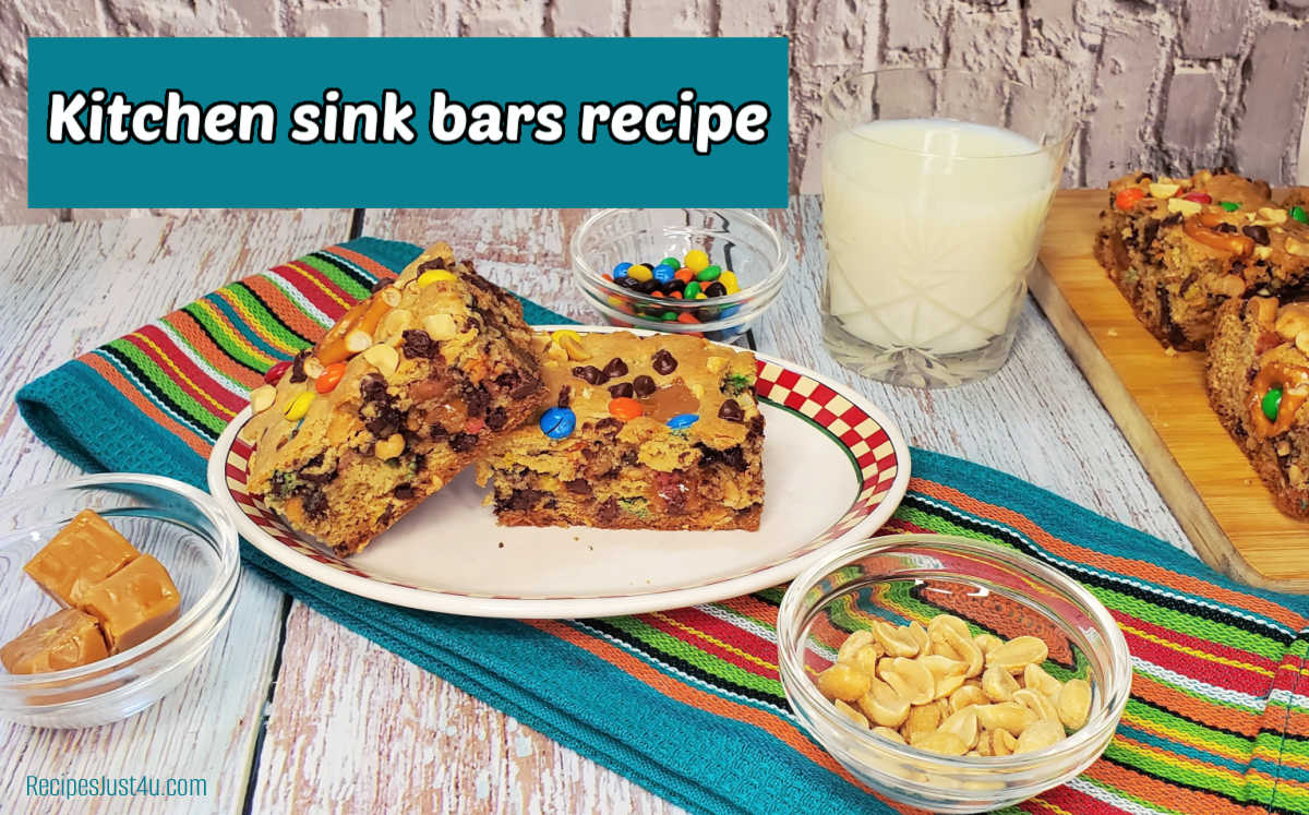 A plate with two cookie bars on it next to a glass of mink, colorful towel and bowl of peanuts. Teal text box reads Kitchen sink bars recipe.