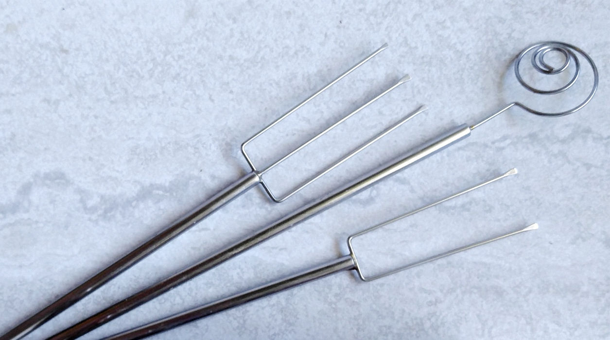 A candy dipping tool set with 2 forks and a small scoop.