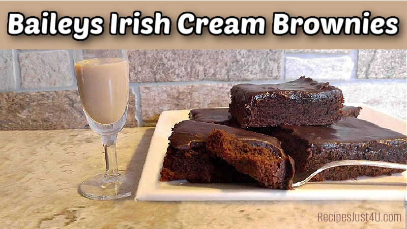 A plate of chocolate fudge brownies with an Irish cream ganache next to a glass of Baileys Irish Cream. Text reads Baileys Irish cream brownies.