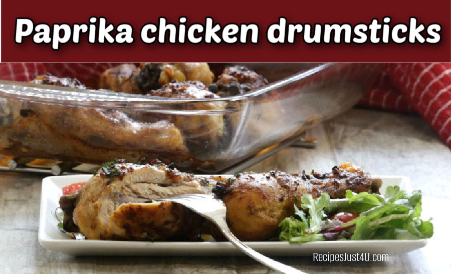 Paprika chicken drumsticks on a white plate with fork and red napkin.