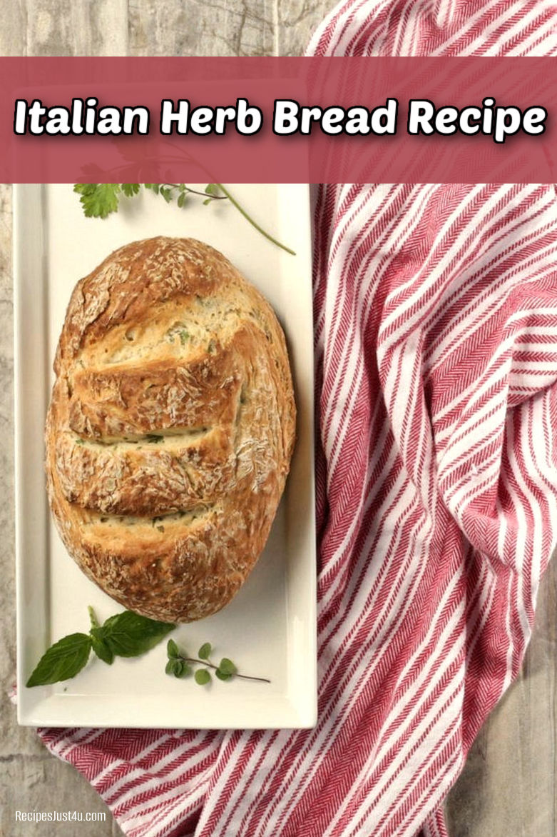 A loaf of Italian herb bread on a long white plate next to a striped red tea towel.